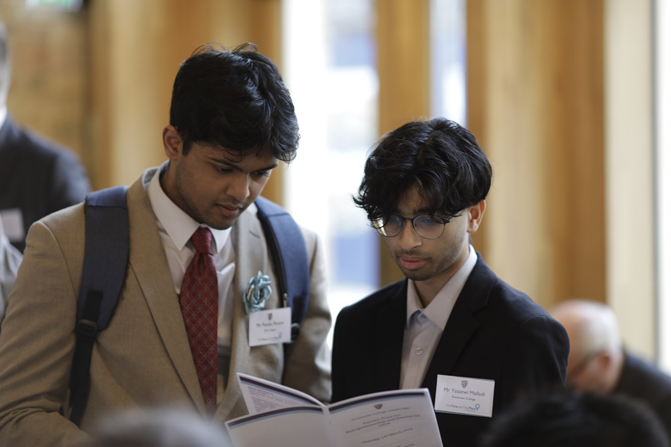 Two students read the programme